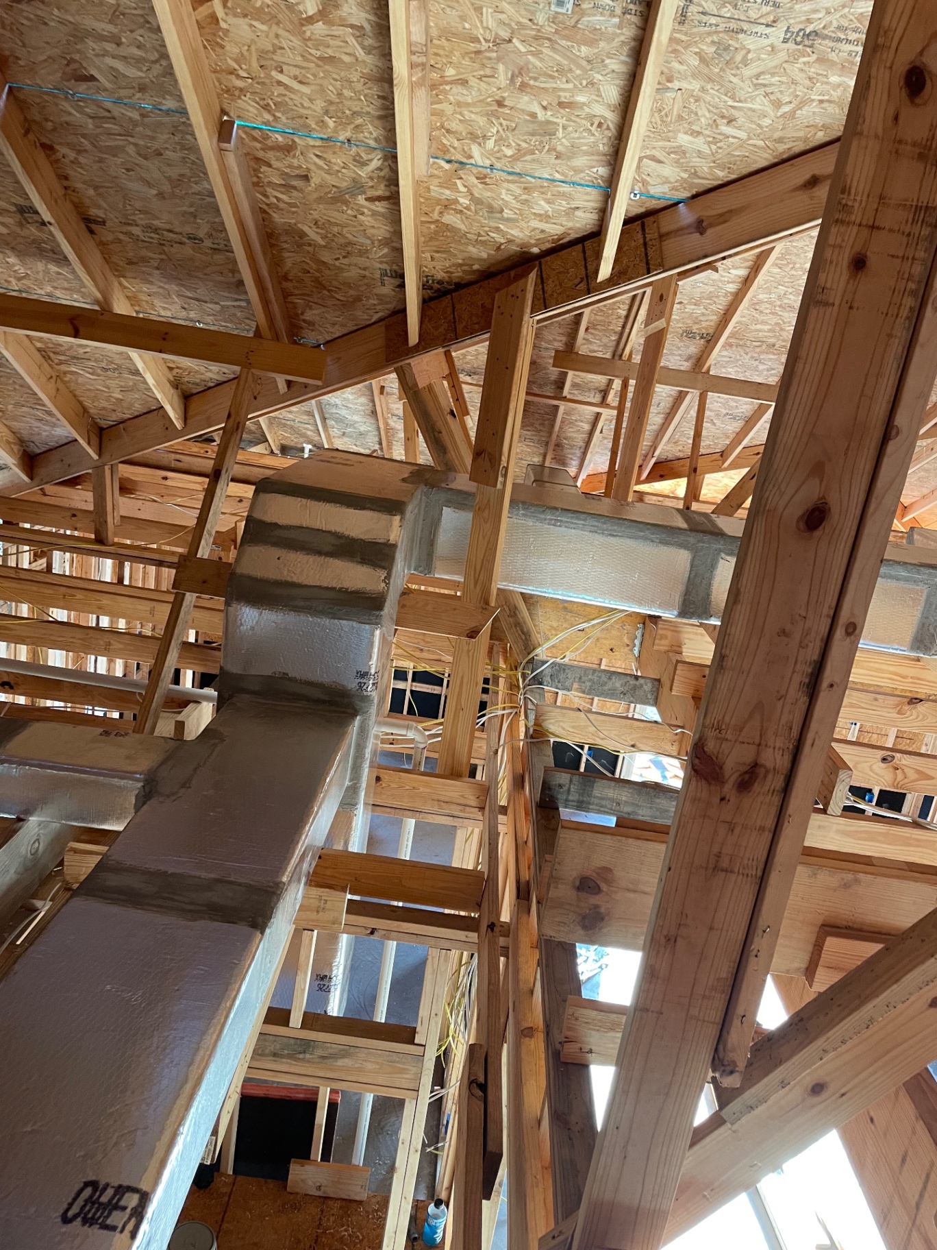 Custom fabricated and sealed supply plenum installed above framing in a new build